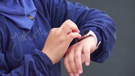 modern technology concept — hand of person checking and navigating a smartwatch on their wrist, outdoors in natural light