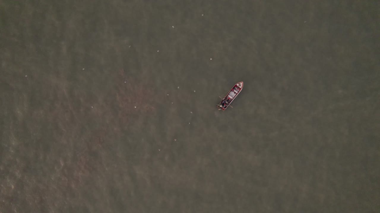 어망을 설정하는 물 위의 작은 어선의 하향식 전망