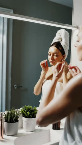 woman's beauty and self-care routine in the bathroom mirror