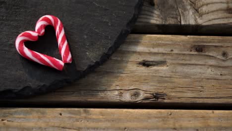 Candy-cane-with-heart-shape-arranged-on-concrete-4k