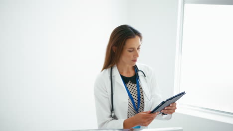 Female-Doctor-With-Digital-Tablet-Checking-Patient-Notes-On-Stairs-In-Hospital