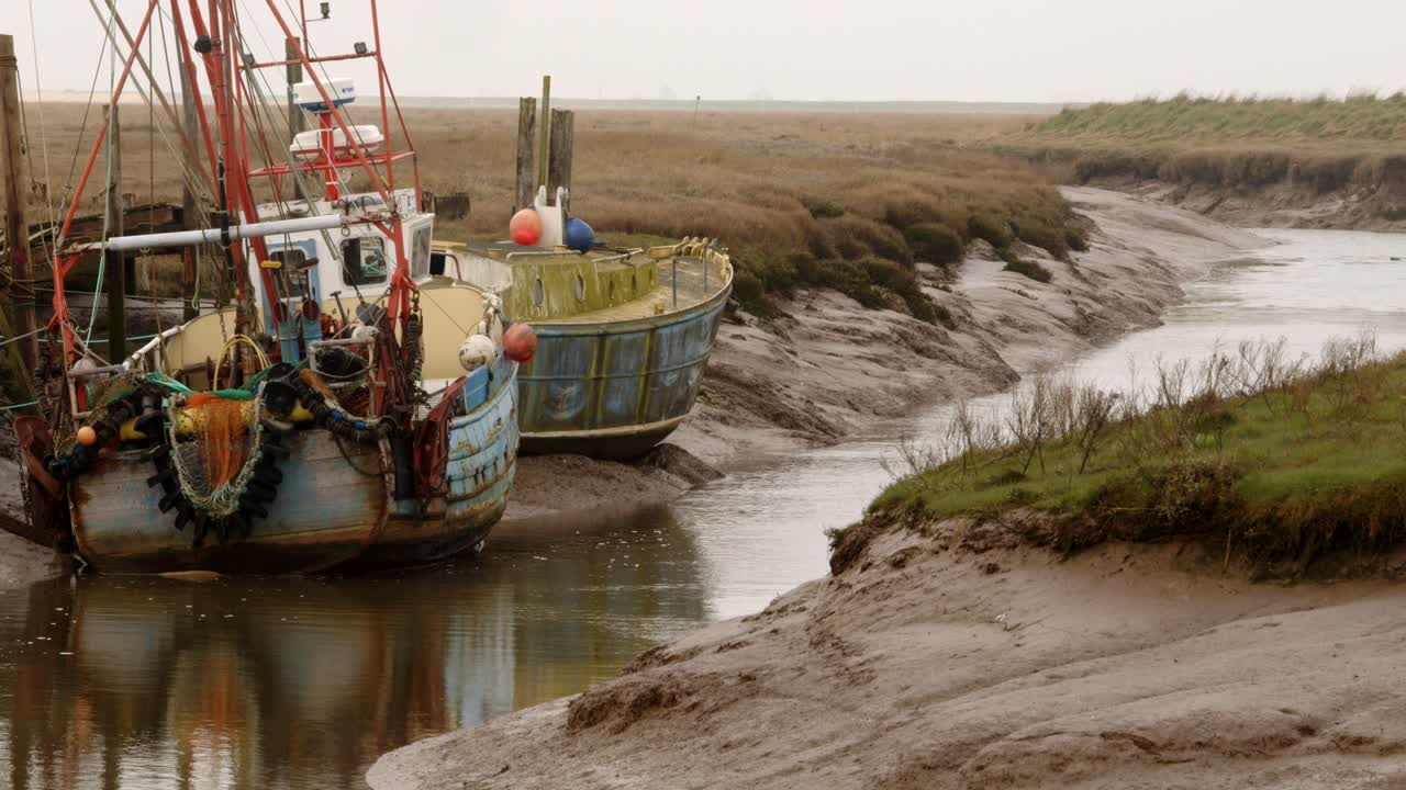 barco de pesca amarrado en un río empinado en gibraltar point, con la marea fuera mostrando bancos de barro