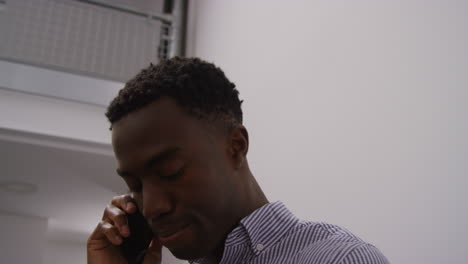 close up of young businessman in office talking on mobile phone looking frustrated and angry shot in real time 1