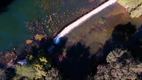 Top-down-view-of-a-drone-passing-over-a-waterfall