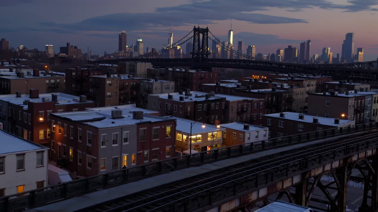 Aerial view of a cityscape at dusk, showcasing a bridge and skyline