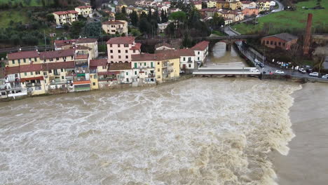 El-Dron-Se-Inclina-Hacia-Arriba-Desde-El-Agua-Turbia-Hasta-Las-Casas-Inundadas-A-Lo-Largo-Del-Río-Arno-En-Florencia,-Italia,-Diciembre-De-2019