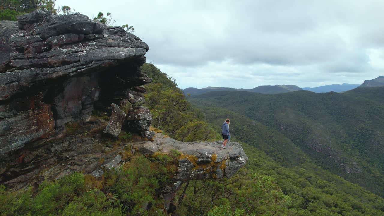 video de cámara 4k de una niña corriendo hacia un niño en el punto de vista de los balcones en el parque nacional grampians en victoria, australia