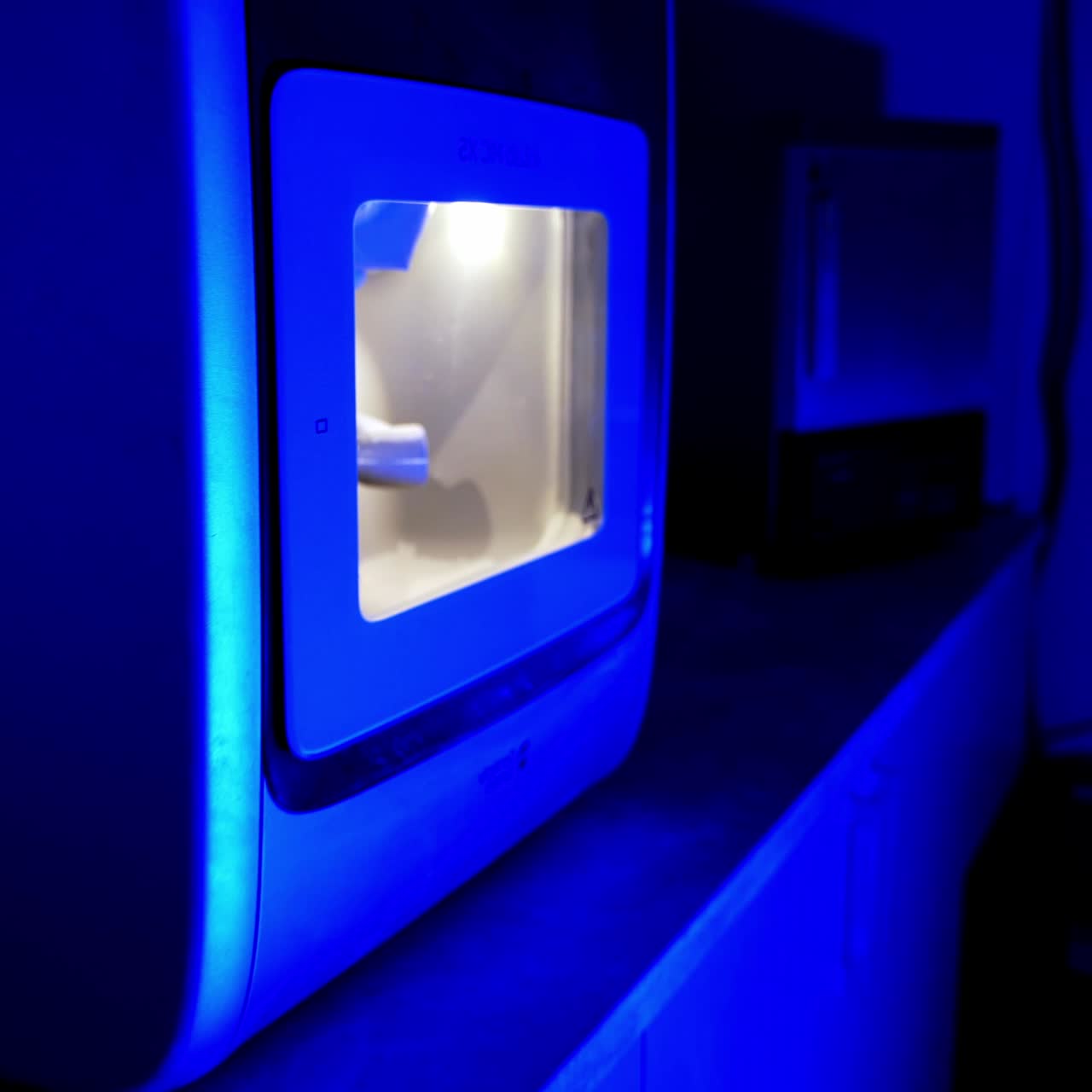 Dental machine in blue light. Advanced equipment for making ceramic teeth. Modern technologies in dentistry