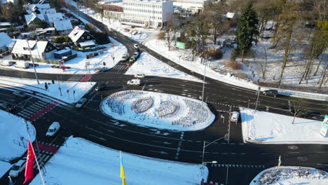 cars driving on black asphalt true a traffic light on a roundabout in the city gdansk poland on a cold sunny winter day