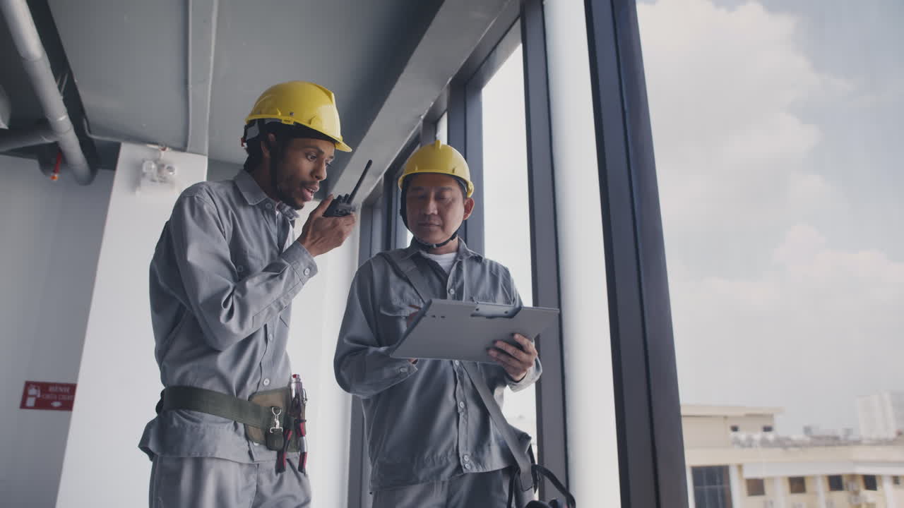 Engineer and Construction Worker Discussing Room Layout