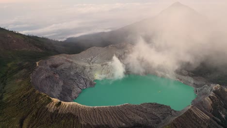 Vista-Aérea-De-Un-Creador-Rocoso-En-El-Volcán-Kawah-Ijen-Con-Lago-Turquesa-De-Agua-Sulfurosa-Al-Amanecer