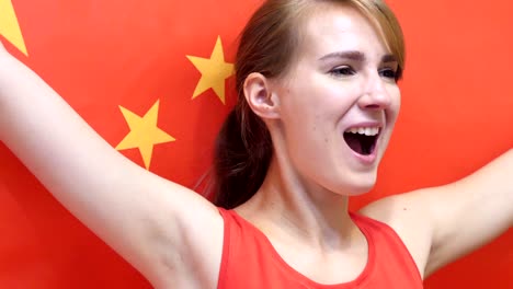 chinese young woman celebrates holding the flag of china in slow motion