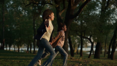padres hija corriendo tomados de la mano luz de sol dorada. personas que se preocupan juntos.