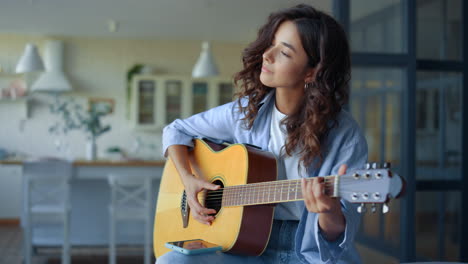 chica tocando la guitarra en la habitación. músico practicando música en un instrumento de cuerda