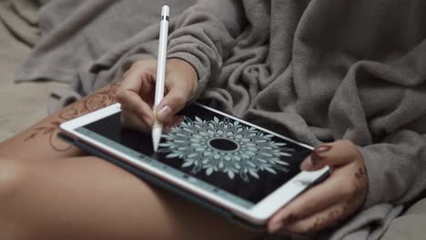 woman drawing mandala on digital tablet