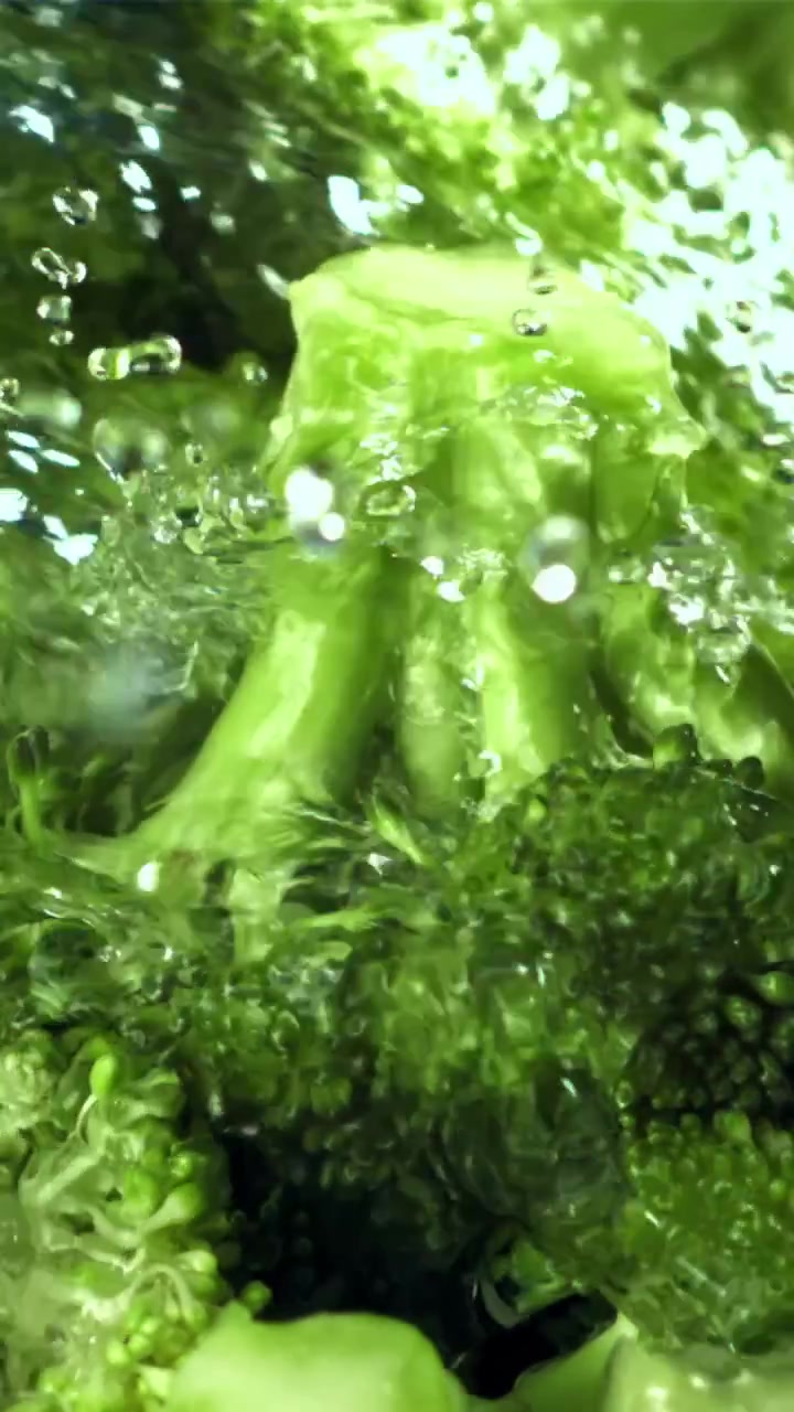 Primo piano di cimette di broccoli verdi sciacquate con acqua