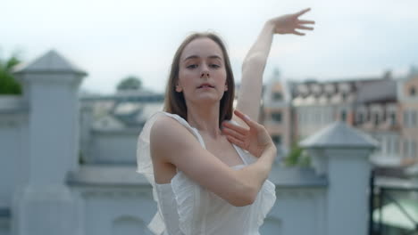 young woman in a white dress on a city rooftop