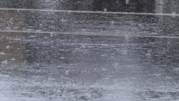 Heavy rain falling on a wet surface