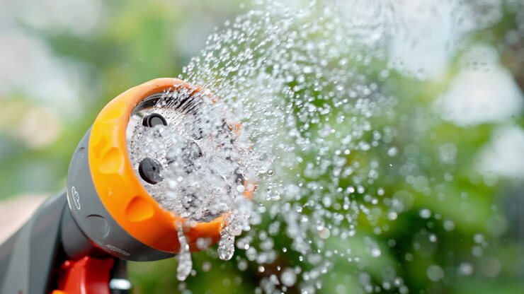 Watering Sprayer Starts Pouring Water in Shower Mode in Slow Motion, Metal Nozzle's Pattern with Dripping Droplets in Macro