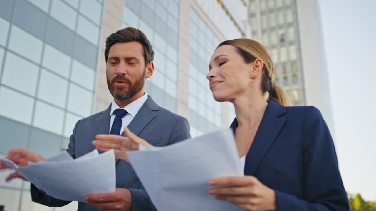 socios caminantes discutiendo contrato en el centro urbano de cerca. socios sonrientes