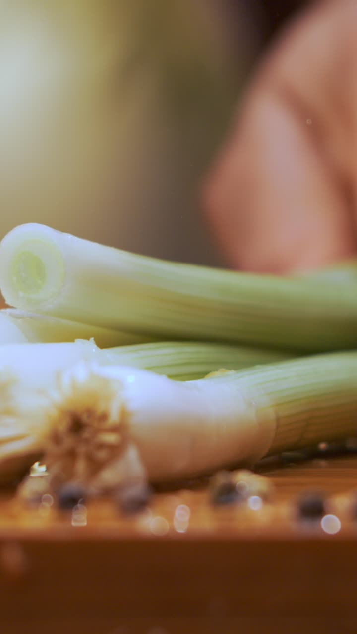 Scallions being cut on a cutting board