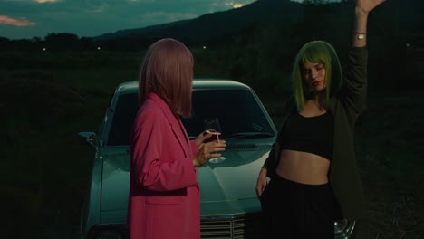 Two Women by a Retro Car at Sunset