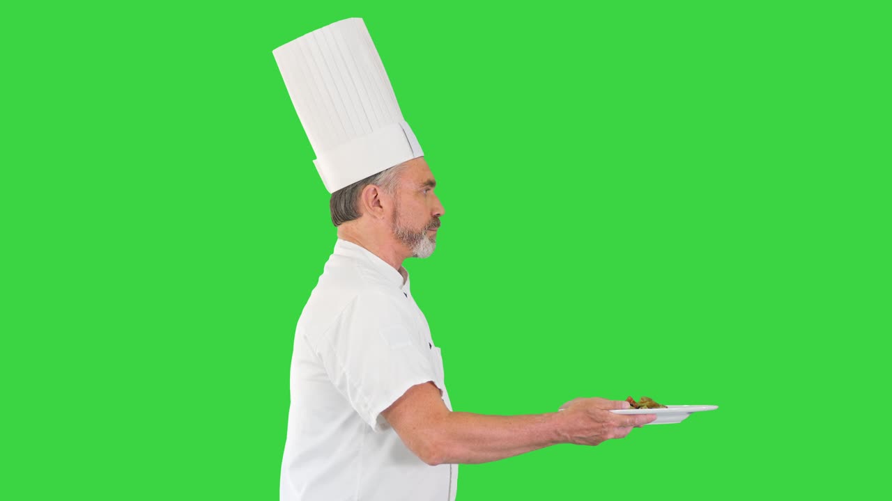 Chef uomo in uniforme bianca che corre con un piatto di insalata su schermo verde, Chroma Key