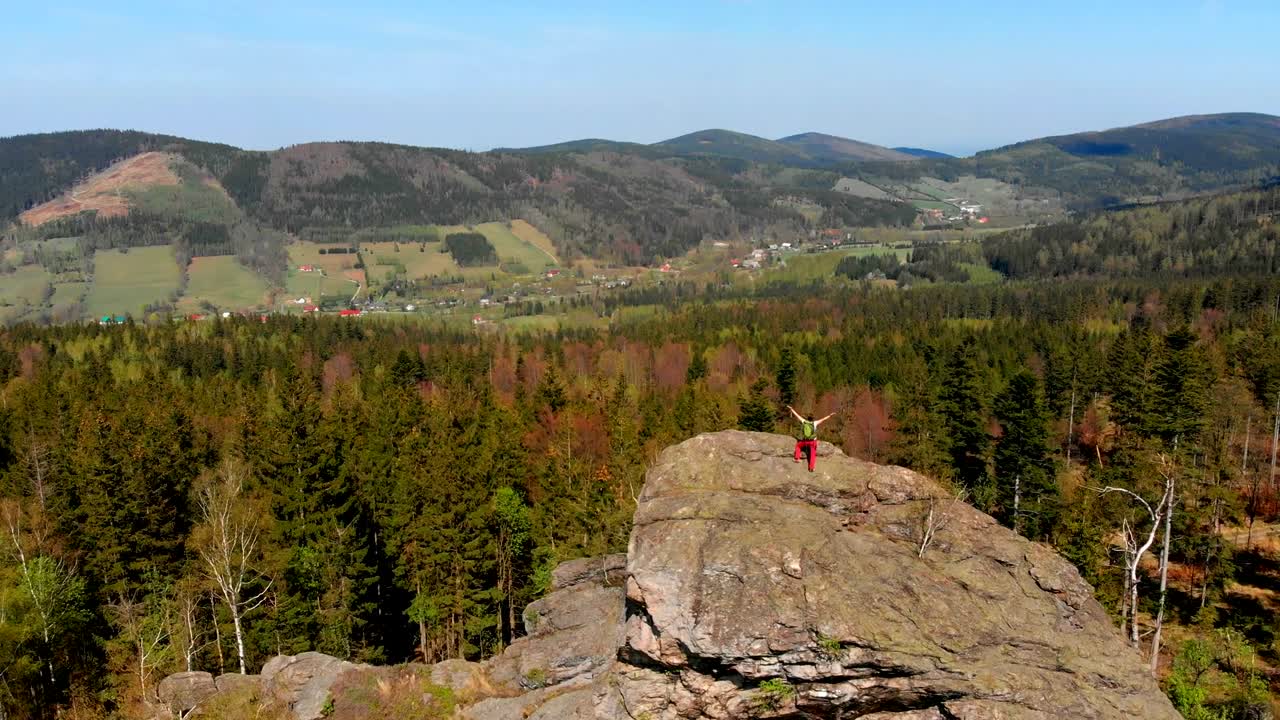 산 꼭대기에 팔을 들고 있는 성공한 젊은 여성.