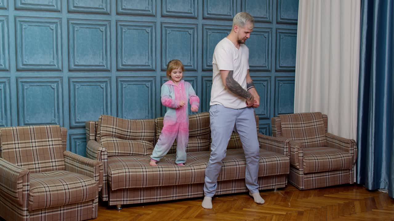 행복한 재미있는 가족 아버지와 아이 아이 딸 춤추고, 소파에 뛰어들고, 집에서 음악을 듣고
