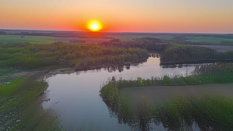 vista aérea sobre un paisaje con un río bajo un amanecer naranja