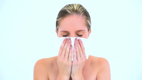 blond woman sneezing in a tissue