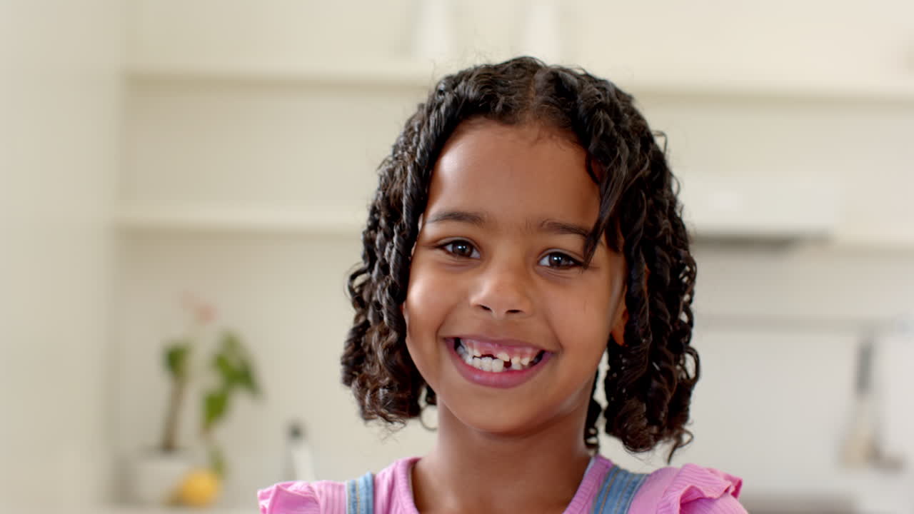 Smiling girl with missing tooth enjoying time at home, feeling happy