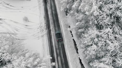 Imágenes-De-Drones-De-Un-Automóvil-Conduciendo-En-El-Camino-Forestal-De-Invierno