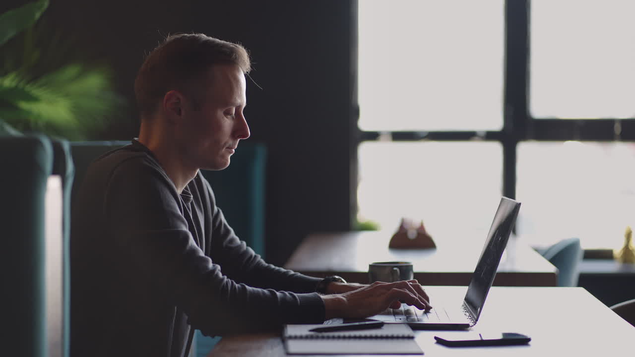 beautiful male developer or student working studying by laptop in cafe. freelance remote work online education self employed