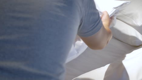 hotel-service-concept,-housekeeper-man-arrange-the-pillow-on-the-bed-with-white-sheet,-make-bed-in-morning