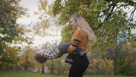 young mother circles her child, has a good time together on a walk. against the backdrop of sunset