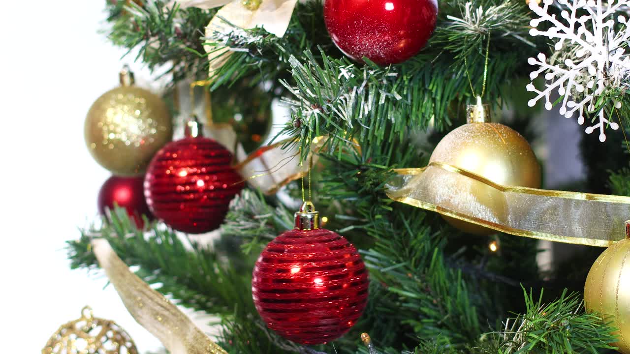 poniendo un ornamento rojo de navidad en el árbol de navidad