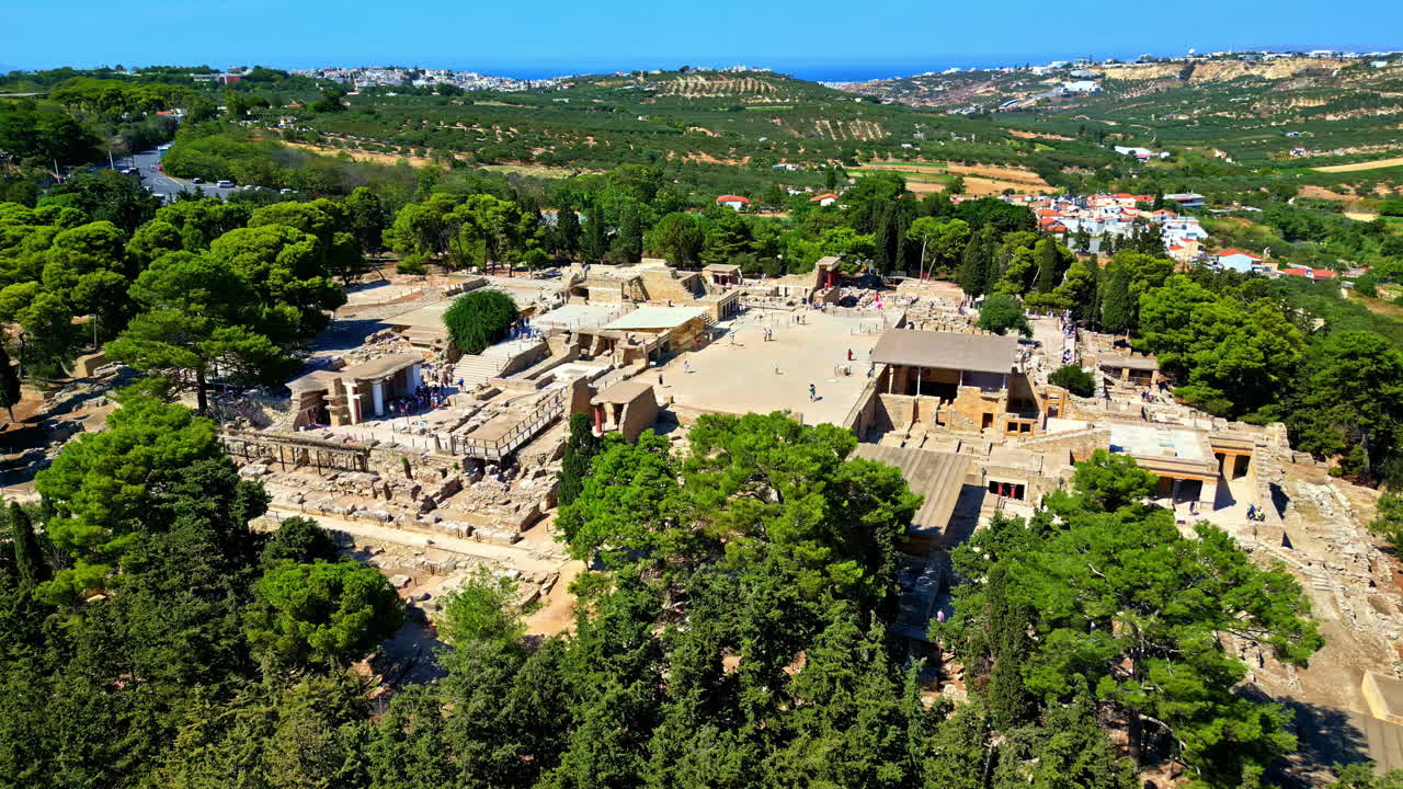 The ancient Knossos Palace ruins in Crete, Greece surrounded by lush trees and rolling hills