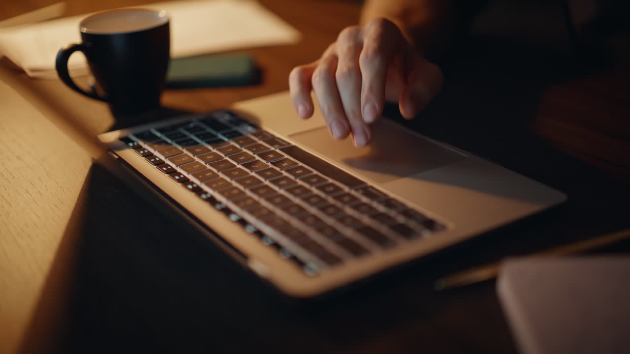 Freelancer hands tapping touchpad laptop browsing website at home office closeup