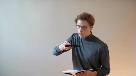 el tipo con gafas toma fotos del texto del libro en un smartphone para digitalizarlo