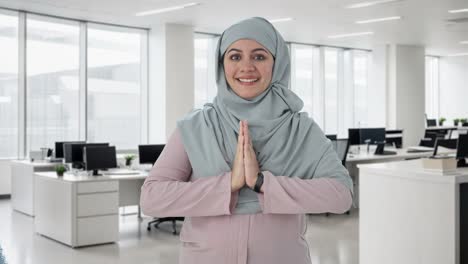 happy muslim businesswoman doing namaste