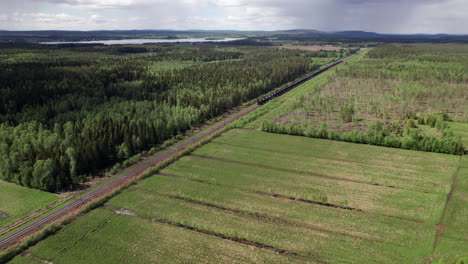 drone view of empty swedish freight train, cargo, scandinavia, kiruna, luleå, forest landscape, pull out,