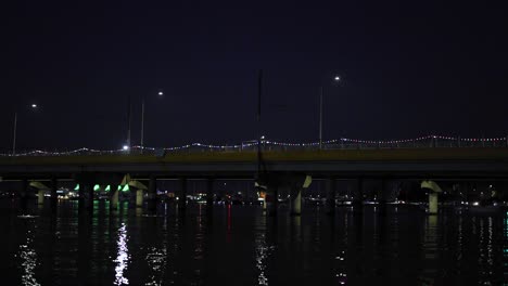 bridge lights reflecting on water at night