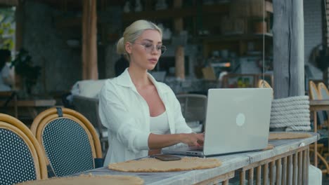 mujer trabajando en una computadora portátil en un café