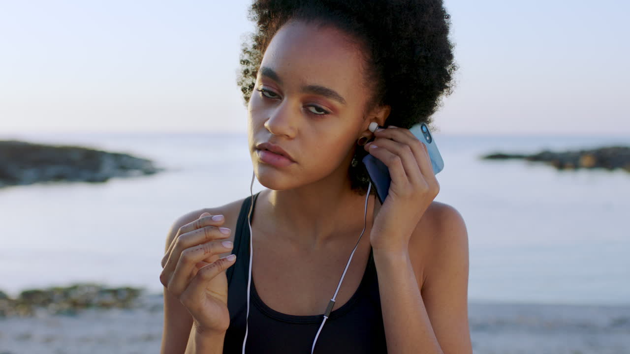 mujer negra, fitness y auriculares de música en la playa