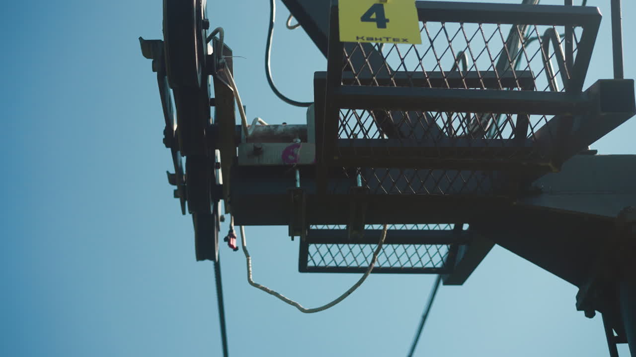 Cable car goes to viewing platform with panorama of mountains. Video depicts transport infrastructure with breathtaking environment and sky view in background