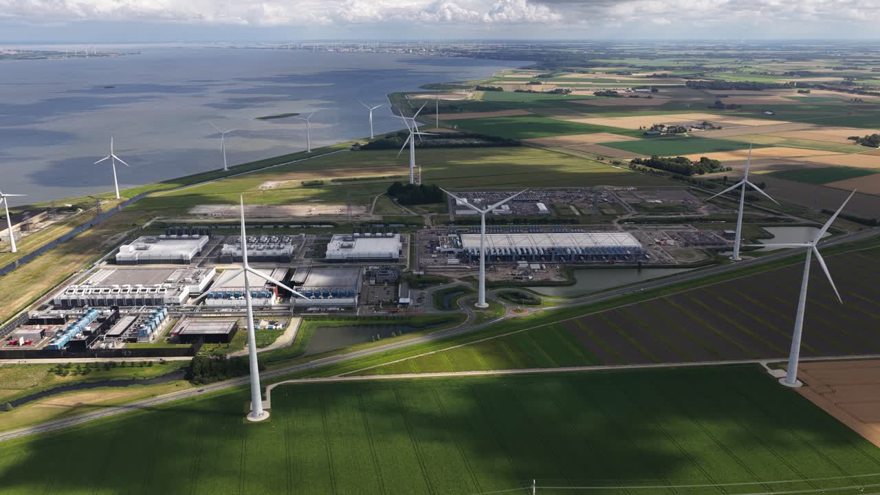 Daytime summer aerial drone video of a large-scale data center in the Eemshaven, The Netherlands, modern computing infrastructure, cloud technology, and high capacity digital processing facilities