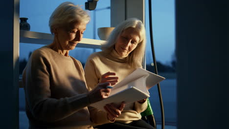 dos mujeres mayores revisando documentos juntas