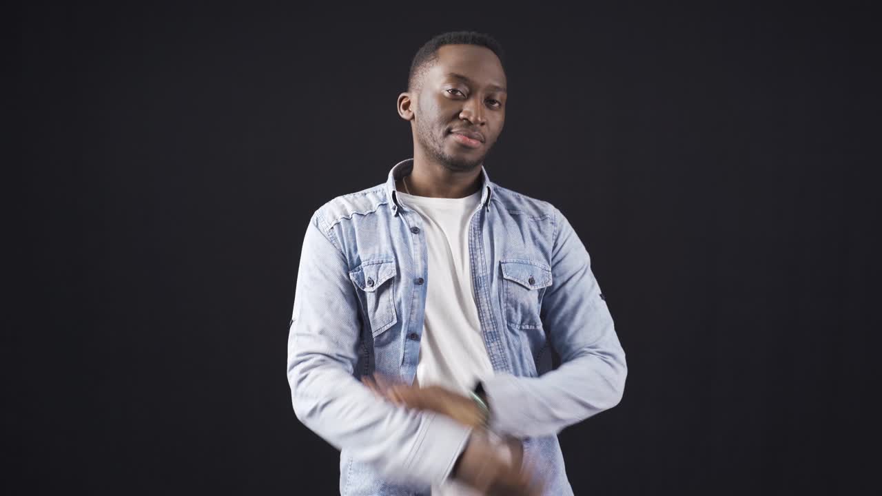 Stylish and handsome African young man with folded arms looking at camera freely and confidently.