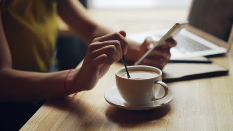 woman working in a cafe with coffee and laptop